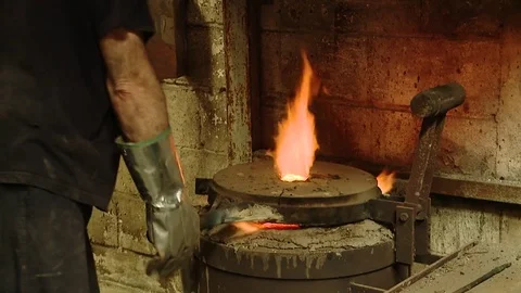 HD. An operator takes a crucible filled with molten silver Stock Footage 78110510