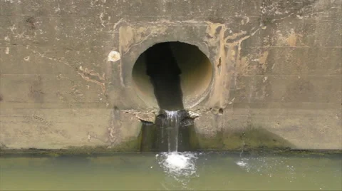 HD Sewage drain pipe empties into water channel Stock Footage 930729