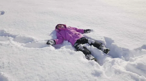 HD Slow-Mo: Cute Little Girl Lying in a Powder Snow Stock-Footage 46364321