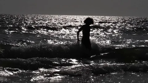 HD Slow Motion. backlight of a young woman standing at the edge of the sea Stock Footage 80093811