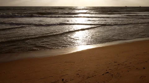 HD slow-motion shot of gentle ocean waves washing onto a golden sandy beach. Stock Footage 341110115