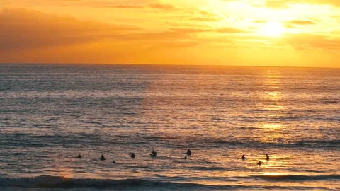 HD Slow Motion - Surfers In Wake of Golden Hour Sunset in Ocean Stock Footage 128936295