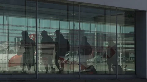HD Travellers walk through shiny glass jet bridge toward airport terminal V7 Stock Footage 120135713