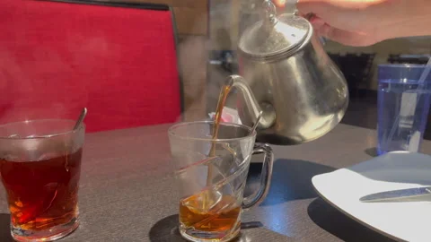HD Turkish tea in a iron tea pot being filled in a glass cup with a man's hand Video stock 230194938