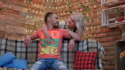 HD Young couple is in studio, the man is sitting on a bench, the wife is huging Stock-Footage 96680712