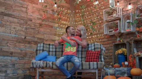 HD Young couple is in studio, the man is sitting on a bench, the wife is huging Video stock 96680764