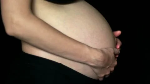 HD1080 Pregnant woman stroking her belly on black background Stock Footage