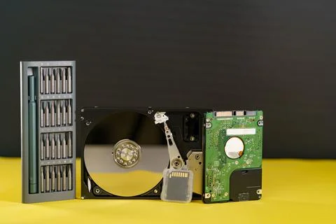 Hdd disk sd card ssd disk with screwdriver repair kit on yellow black backgro Stock Photos