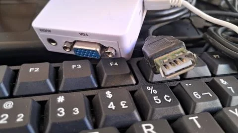 HDMI to VGA adapter on a computer keyboard. Digital video converter for legacy Foto stock