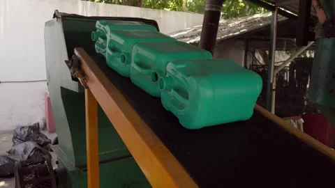 HDPE Plastic Containers on Conveyor Belt Entering Shredder for Recycling Stock Footage 346642891