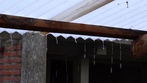 HDR of a closeup of large drops of intense rain falling from the calamine roof Stock Footage 164620570