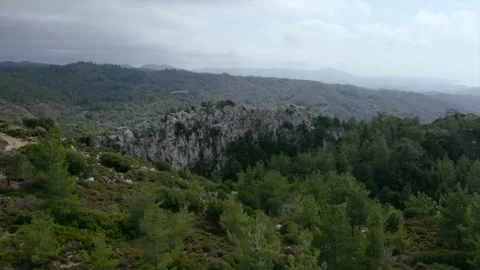 HDR Smooth flight of a drone over a rock among a green forest Vídeos de archivo 169031703
