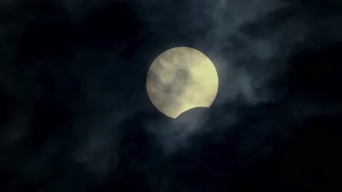 Hdr sun eclipse by moon at cloudy sky, real 4k video of solar eclipse Stock Footage 133987996
