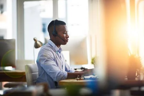 He is all about solving problems. a male agent working in a call centre. Stock Photos