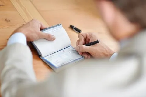 He always pays on time. Cropped closeup shot of a businessman signing cheques. Stock Photos