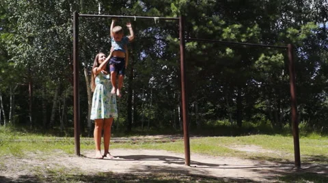 He boy hangs on the bar with my mother Stock Footage 54661274