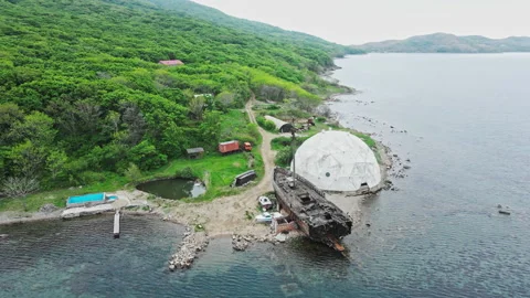 He camera pans over a wrecked wooden sailing ship at an old military base Stock Footage 155029354