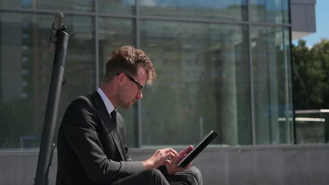 He cannot wait until he gets to the office. Businessman working in the street Stock Footage 143908995