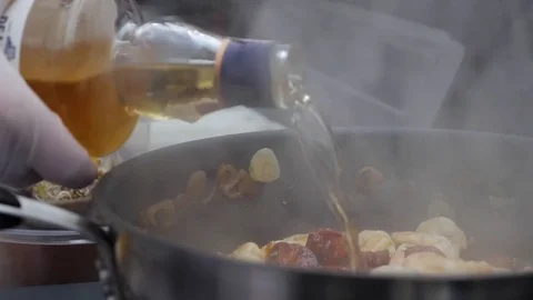 He chef prepares a black paste with seafood and whiskey at the festival of food Stock Footage 84263885