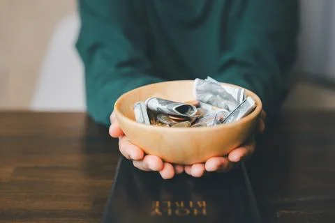 He decided to donate portion of his earnings as tithe, giving money and coi.. Stock Photos