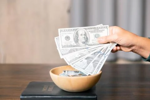 He decided to donate portion of his earnings as tithe, giving money and coi.. Stock Photos