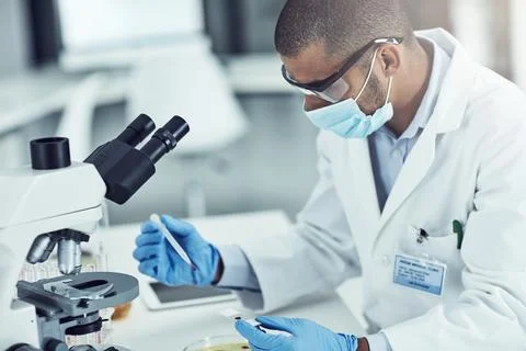 He has strong problem-solving skills. a young male scientist working in his lab. 写真素材