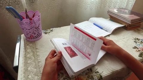 He leafs through the book. Stock Footage 78990236