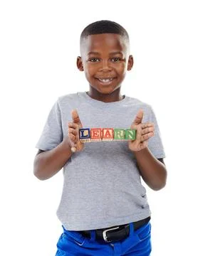 He loves to learn. Studio shot of a cute little boy holding building blocks that Fotos de archivo