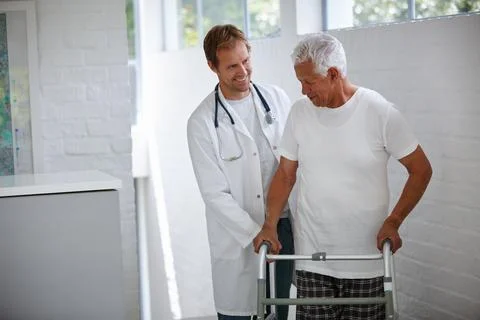 He needs a little bit of support. a male doctor assisting his senior patient 스톡 사진