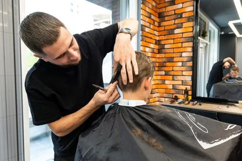 He posed in a barbershop studio while the professional posed for a small child Stock Photos