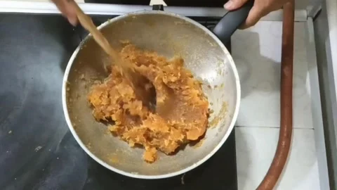 He process of cooking pineapple jam by stirring in a large pan over low hea.. Stock Footage 266695648