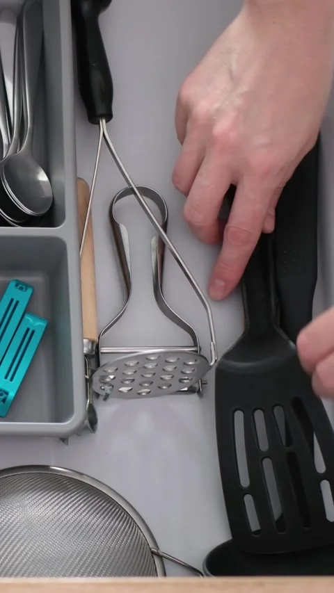He pulls out the kitchen drawer with various kitchen utensils in the cutlery Video stock 315660971