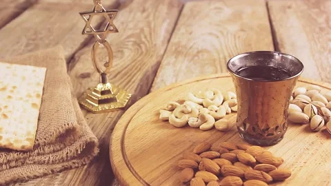 He puts his hands on the table with matzo and sets the wine for the Kiddush Stock Footage 150740846