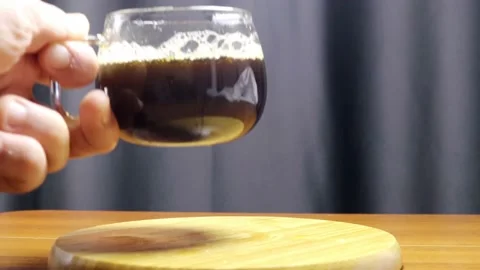 He puts the steaming fresh filter coffee in a glass mug on the table 스톡 동영상 184600832