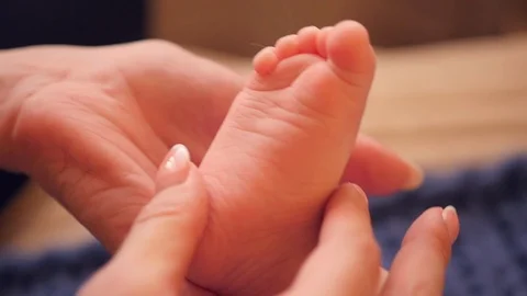 He is stroking his child's small foot with his hands. HD, 1920x1080. slow motion Stock Footage 87903126