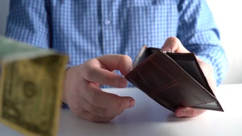 He takes a dollar and puts it in his wallet Stock Footage 166514733