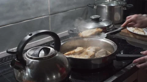 He takes the fried fish out of the pan with hot oil and a special spoon with Stock Footage 146859357