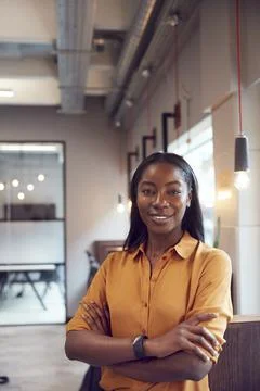 Head And Shoulders Portrait Of Smiling Young Businesswoman  Working In Modern Stock Photos