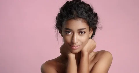 Head and shoulders shot of a naked young female model with smooth skin isolated Stock Footage
