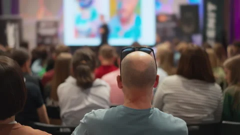 The head of a bald man from behind, he looks at the stage. Young crowd watches Stock Footage 269004413