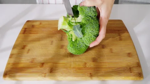 Head of broccoli and a kitchen knife on a wooden cutting board. Stock Footage 308151663