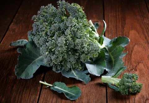 Head of broccoli with leaves in a table Stock Photos