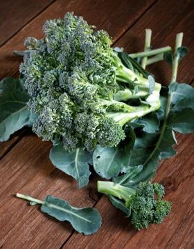 Head of broccoli with leaves in a table Stock Photos