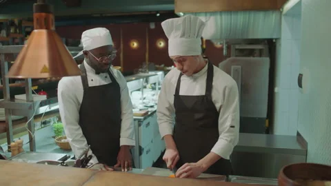 Head Chef Cooking in Restaurant Kitchen and Teaching Apprentice Stock Footage 273451470