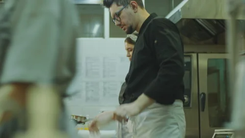 Head Chef Helping Female Apprentice with Flambe in Restaurant Kitchen 스톡 동영상 270152991