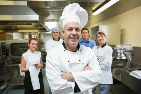 Head chef posing with team behind him Fotos de archivo