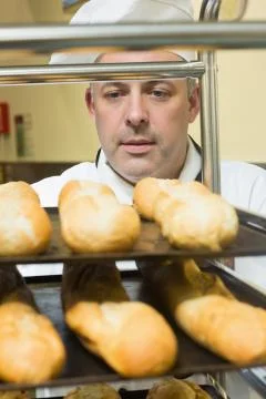 Head chef pushing a trolley with baguettes on it Stock Photos