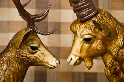 Head of a deer and the head of an ibex, plastic, gazing longingly into each o Stock Photos