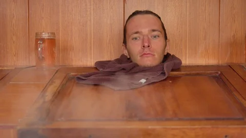 The head of a good looking man fading behind steam inside a sauna box Video stock 119801294