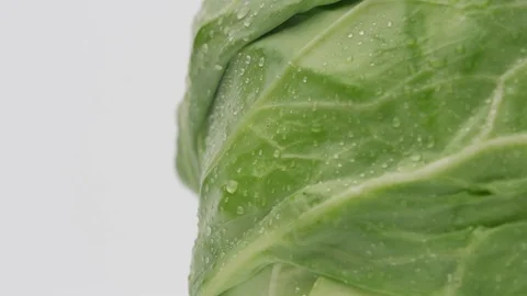 Head of green cabbage with drops of water rotates Stock Footage 129850503